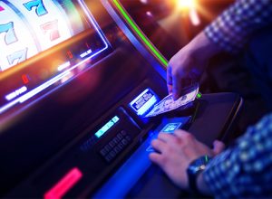 Man putting money in gaming machine