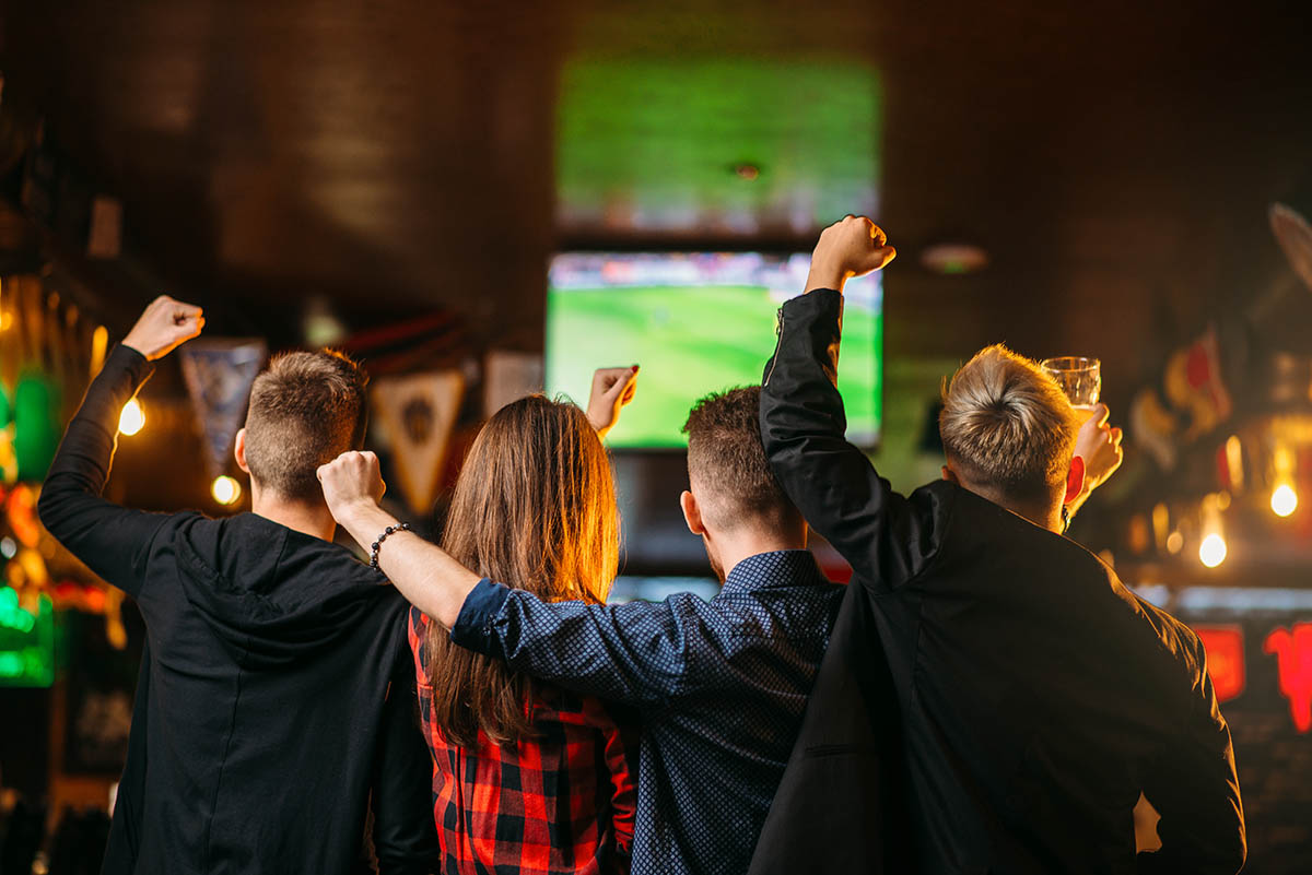 Friends cheering at sports bar