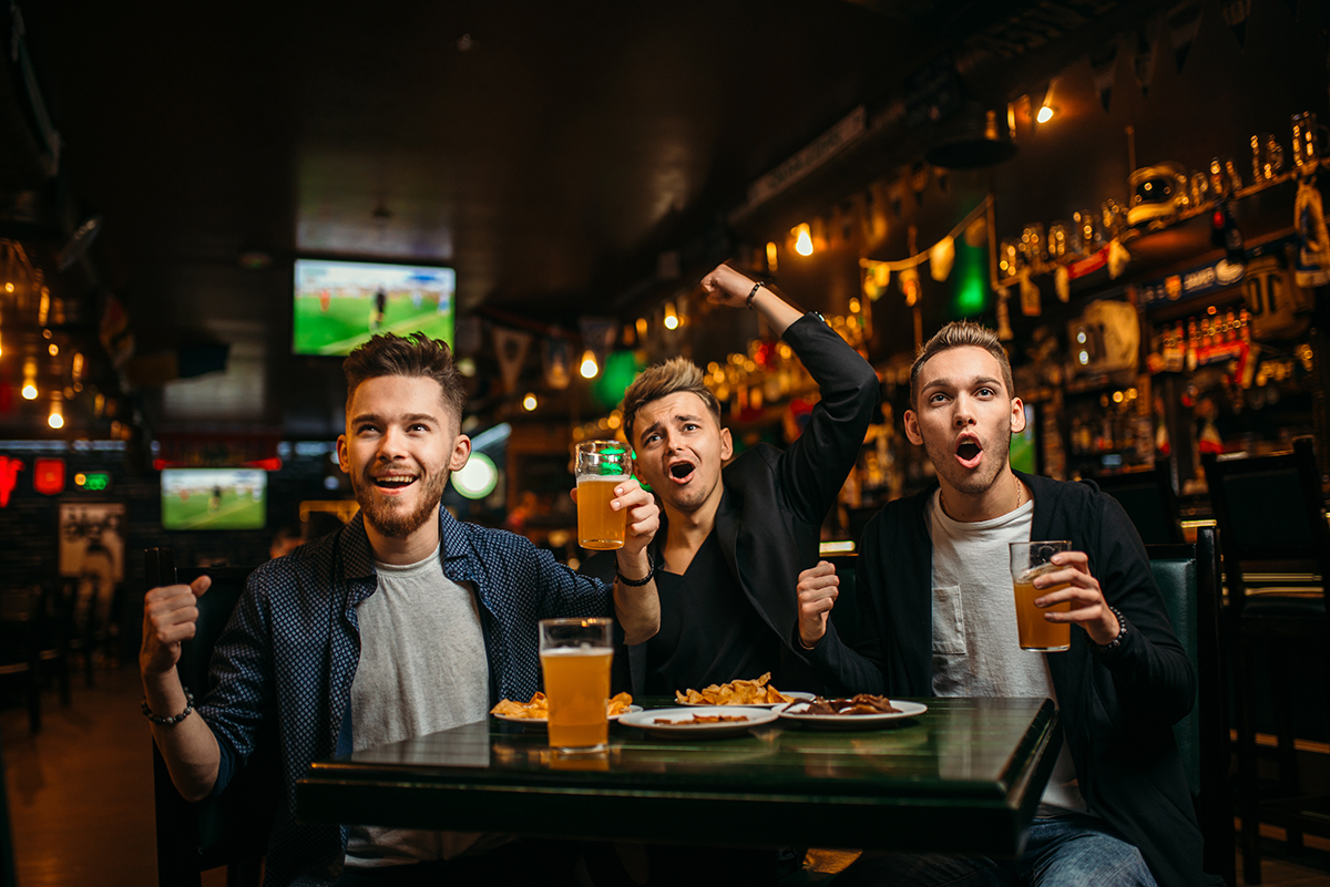 Friends cheering at sports bar